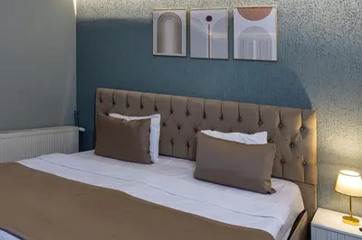 a bed with two pillows and two pictures on the wall at LINNGA HOTEL & SUITE in Istanbul