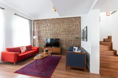 a living room with a red couch and a brick wall at Bright Loft with 3 bedrooms and terrace in Galata in Istanbul