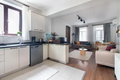 a kitchen with white cabinets and a living room at Bright Loft with 3 bedrooms and terrace in Galata in Istanbul