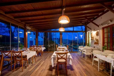 a restaurant with tables and chairs and large windows at Beta Home Sapanca in Sapanca
