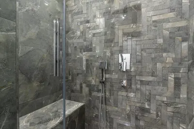 a bathroom with a shower with a stone wall at Brand New Duplex wParking 2BD2Bath Home #336 in Istanbul