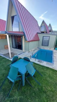 a blue table and chairs in front of a house at Patya BUNGALOV in Dereköy