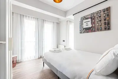 a white bedroom with a large bed and large windows at Duplex Penthouse wparking 3BD2Bath Views! #340 in Istanbul