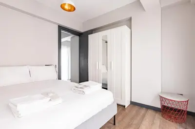 a bedroom with a white bed and a red stool at Cozy Bright wParking 2BD1Bath Central Home!#338 in Istanbul