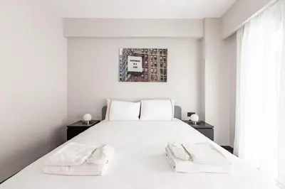 a white bedroom with a large white bed with two towels at Cozy Bright wParking 2BD1Bath Central Home!#338 in Istanbul