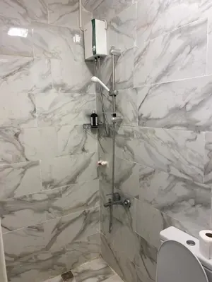 a bathroom with a shower with white marble walls at hotel YENİkapı in Istanbul