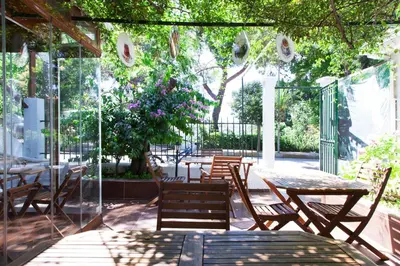 a patio with tables and chairs and a tree at Orhan Kutbayin Evi in Buyukada
