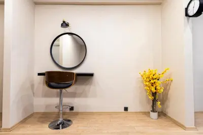 a mirror and a chair and a vase with flowers at The Business Class Suit Karakoy in Istanbul