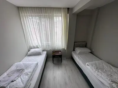 two twin beds in a room with a window at HOTEL KOCABASOGLU in Istanbul