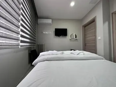 a bedroom with a large white bed and a tv at HOTEL KOCABASOGLU in Istanbul