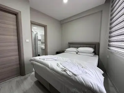 a bedroom with a bed with white sheets and a window at HOTEL KOCABASOGLU in Istanbul