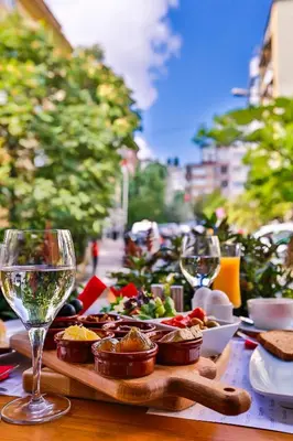 a table with a plate of food and wine glasses at Business Life Hotel & Spa Şişli in Istanbul