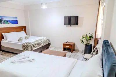 a hotel room with two beds and a flat screen tv at City Hall Apart Hotel Sultanahmet in Istanbul
