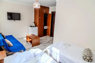 a hotel room with two beds and a blue chair at City Hall Apart Hotel Sultanahmet in Istanbul