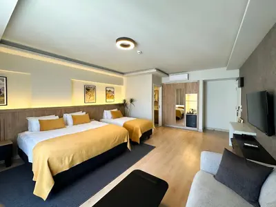 a hotel room with two beds and a tv at Dugi Hotel in Istanbul