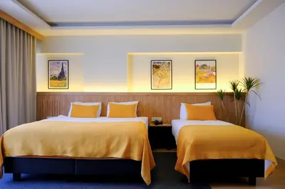 two beds in a hotel room with yellow sheets at Dugi Hotel in Istanbul