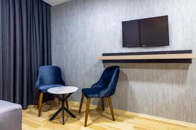 two chairs and a table with a tv on a wall at The Business Class Hotel in Istanbul