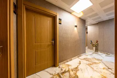 a wooden door in a hallway with a marble floor at The Business Class Hotel in Istanbul