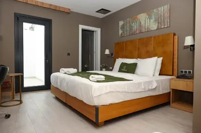 a bedroom with a large bed with a wooden headboard at Gardenmode Airport Hotel in Taşoluk
