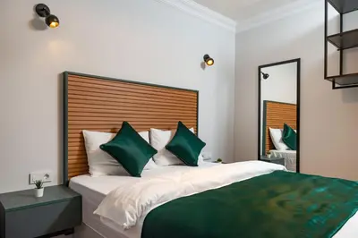 a bedroom with a large bed with green and white pillows at G&B MANSION in Istanbul