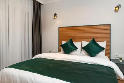 a bedroom with a large bed with green and white pillows at G&B MANSION in Istanbul