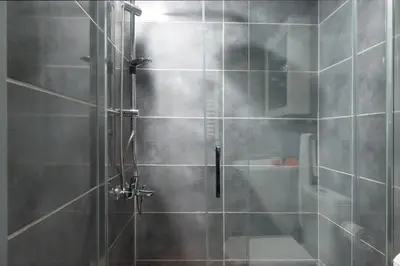 a shower with a glass door in a bathroom at G&B MANSION in Istanbul