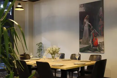 a dining room with a table with chairs and a painting at Ramada by Wyndham Karacabey in Bursa