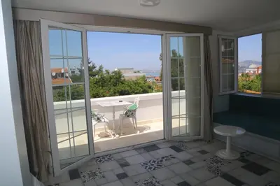 a room with a view of a balcony with windows at Buyukada Cankaya Hotel in Buyukada