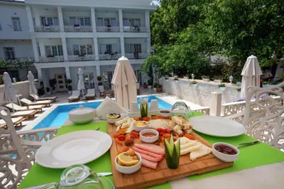 a tray of food on a table next to a pool at Buyukada Cankaya Hotel in Buyukada