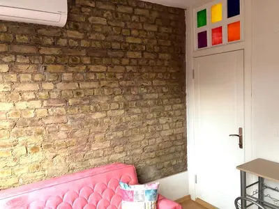a pink couch in front of a brick wall at Istanberry - Dream Apartments in Istanbul