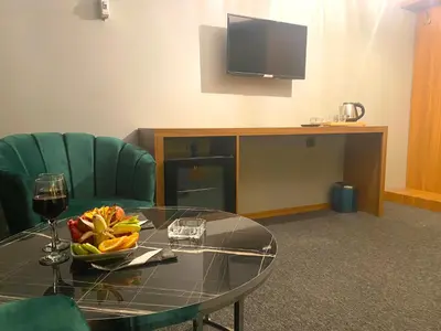a table with a bowl of fruit and a television at Rosse Hotel in Esenyurt