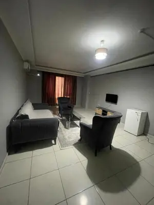 a living room with a bed and a desk and chairs at Rosse Hotel in Esenyurt