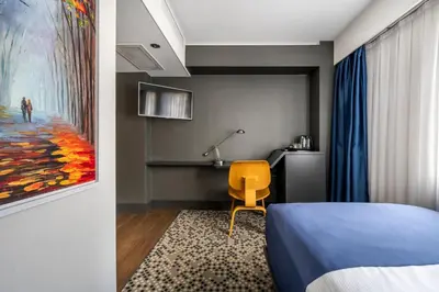a bedroom with a blue bed and a yellow chair at Misa Hotel in Istanbul