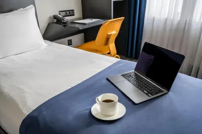 a laptop on a bed with a cup of coffee at Misa Hotel in Istanbul