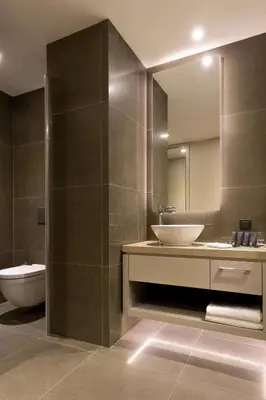 a bathroom with a sink and a toilet and a mirror at AC Hotel Istanbul Macka in Istanbul