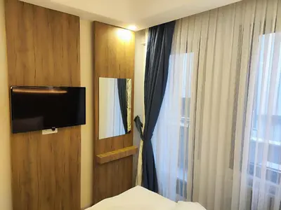 a bedroom with a tv and a bed and a window at Hotel Esve Istanbul in Istanbul