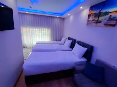 a room with two beds and a couch and a television at BlueRoyal Grand Bazaar in Istanbul