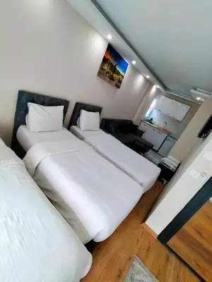two beds in a small room with white sheets at BlueRoyal Grand Bazaar in Istanbul