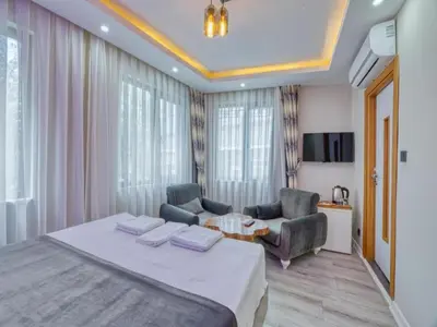 a bedroom with a bed and two chairs and a table at GALATAGREENAPPLEHOTEL in Istanbul