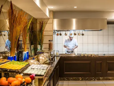a chef standing in a kitchen preparing food at Rox Hotel Istanbul in Istanbul