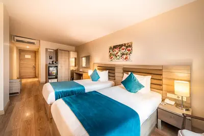 a hotel room with two beds and a television at Rox Hotel Istanbul in Istanbul