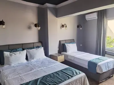two beds sitting next to each other in a bedroom at City Park Suites City Center Corlu in Corlu