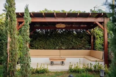 a bench under a pergola in a garden at VillaQua Boutique Hotel in Sile