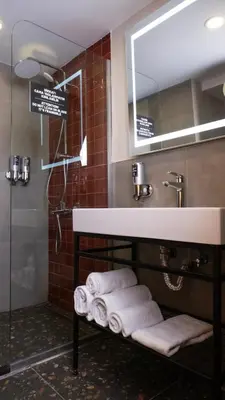 a bathroom with a sink and a shelf with towels at BeL LETTO HOTEL in Istanbul