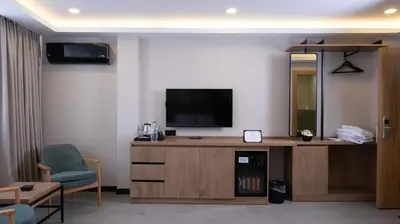 a living room with a television and a couch and a chair at BeL LETTO HOTEL in Istanbul