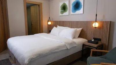 a bedroom with a bed with white sheets and a chair at BeL LETTO HOTEL in Istanbul
