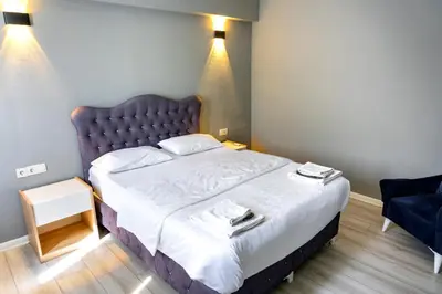 a bedroom with a large bed and a blue chair at Rio's Hotel AİRPORT in Istanbul
