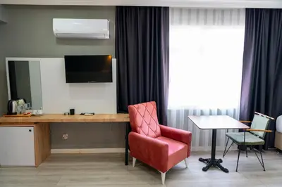 a room with a desk and a chair and a television at Rio's Hotel AİRPORT in Istanbul