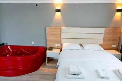 a bedroom with a large bed with a red tub at Rio's Hotel AİRPORT in Istanbul