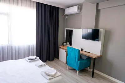 a hotel room with a bed and a desk and a television at Rio's Hotel AİRPORT in Istanbul